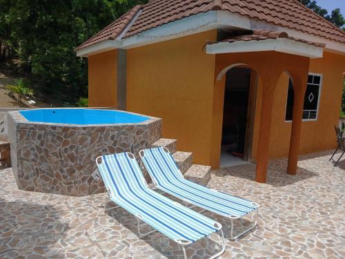 two lounge chairs sitting next to a swimming pool at Skyview Palace in Morant Bay