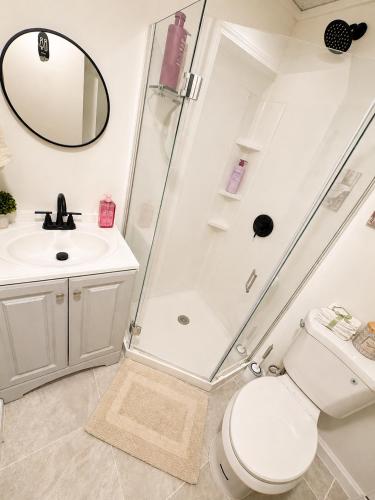 a bathroom with a shower and a toilet and a sink at Elegant Boutique Stay in Lilburn