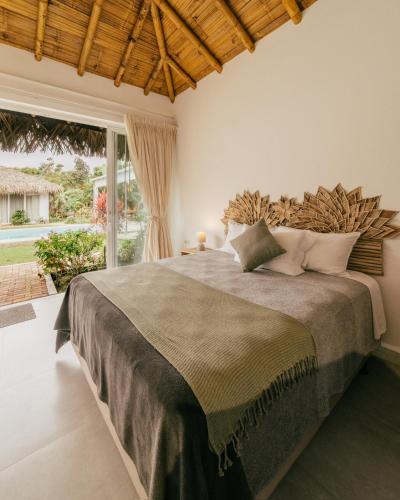 a bedroom with a large bed and a large window at Vikara in Olón