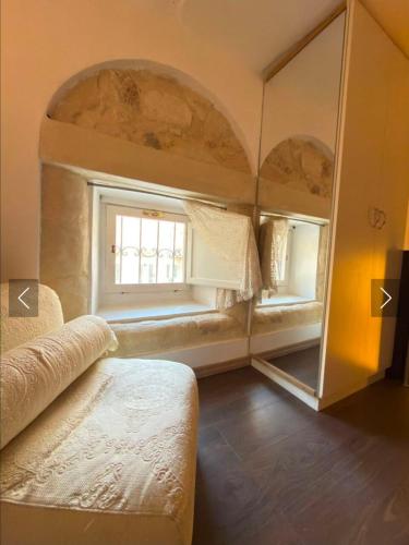 a bedroom with a mirror and a bed and a window at G & N Luxury House in Lecce