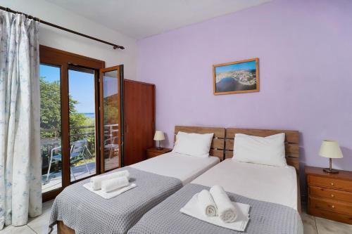 a bedroom with two beds and a large window at Athina Villa in Koinyra