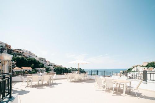 a patio with tables and chairs and the ocean at Laz Palace in Ulcinj