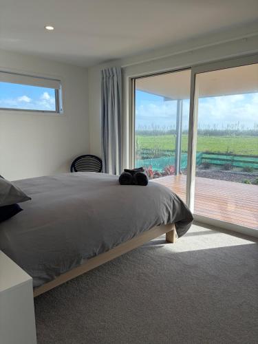 a bedroom with a large bed and a large window at Carters Beach Escape in Carters Beach