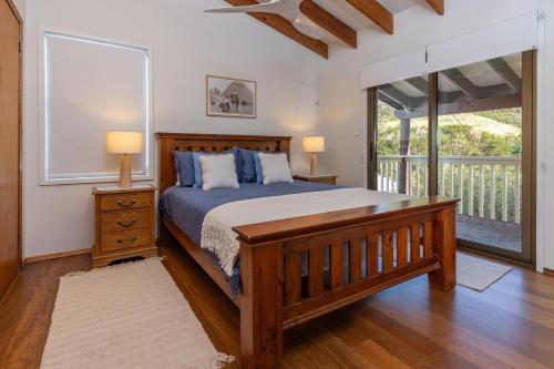 a bedroom with a large bed and a balcony at Lawsons at Blueys in Blueys Beach
