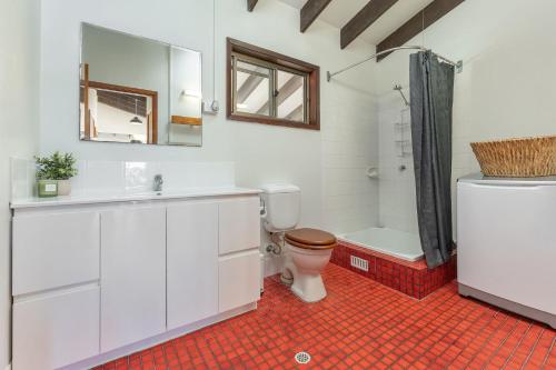 a bathroom with a toilet and a sink and a shower at Lawsons at Blueys in Blueys Beach