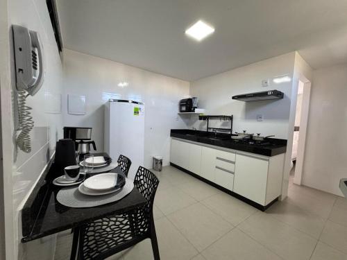 a kitchen with a table and a table and chairs at M e M Studio novo 107 in Ipatinga