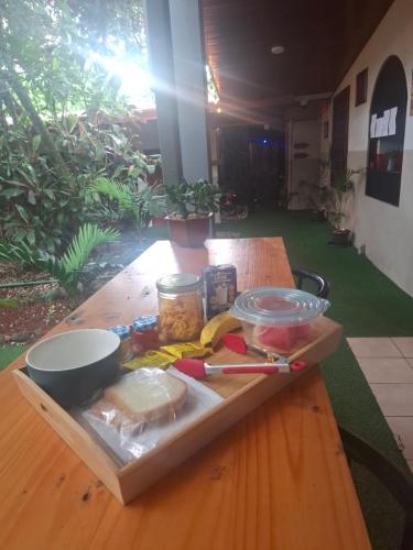 a wooden table with a cutting board with food on it at ApartHotel Villa Pacande & Rooms in Alajuela