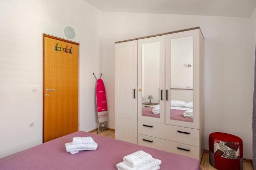 a bedroom with a purple bed and a large cabinet at Maremy in Zadar