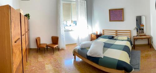 a bedroom with a bed and two chairs in it at CASA di Pi in Bologna