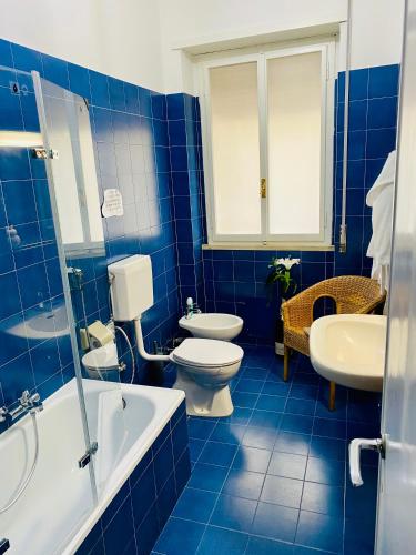a blue tiled bathroom with a toilet and a sink at CASA di Pi in Bologna