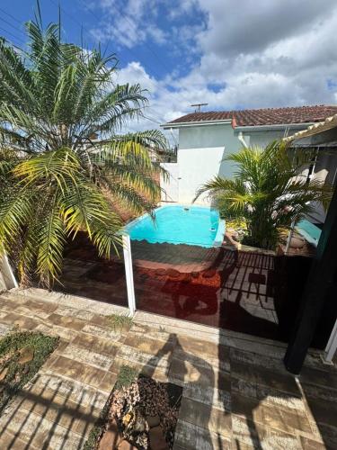 a pool in the backyard of a house with a palm tree at 10 - Casa completa com piscina, Wi-Fi e Garagem in São Leopoldo