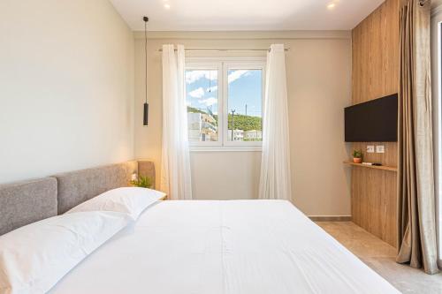 a bedroom with a white bed and a window at New Dhermi Icon 2 - Parking in Dhërmi