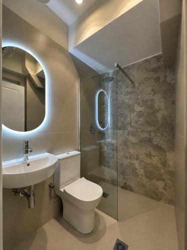 a bathroom with a toilet and a sink and a shower at Angelland Luxury Suites in Nafpaktos