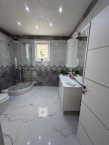 a bathroom with a sink and a toilet and a tub at Luksuzna kuća sa bazenom in Modriča
