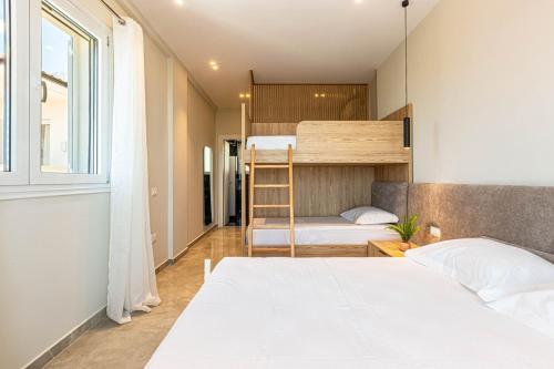 a bedroom with two beds and a bunk bed at New Dhermi Icon 3 - Parking in Dhërmi