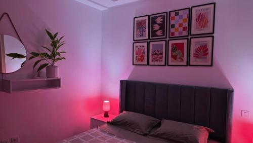 a bedroom with a bed with a pink light at Cozy Urban Nest in La Marsa