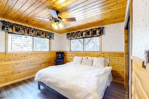 a bedroom with a bed and a ceiling fan at Idyllic Cabin in the Woods: Cozy Crestline Retreat in Arrowhead Highlands