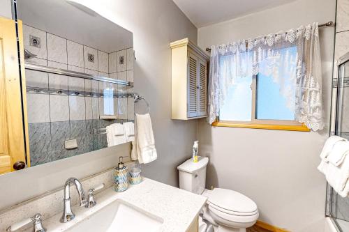 a bathroom with a toilet and a sink and a window at Idyllic Cabin in the Woods: Cozy Crestline Retreat in Arrowhead Highlands