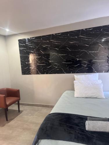 a bedroom with a bed and a painting on the wall at The Gardens view lodge in Bushbuckridge