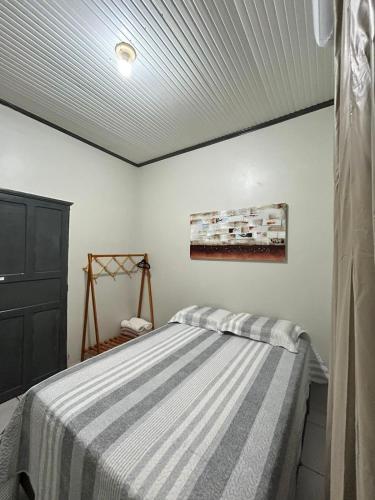a bedroom with a bed with a striped blanket at M&A Hospedagem in Cruzeiro do Sul