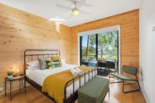 a bedroom with a bed and a large window at Hudsons Hideaway - Cosy Eco Cabin, Rainforest Walks in Dorrigo