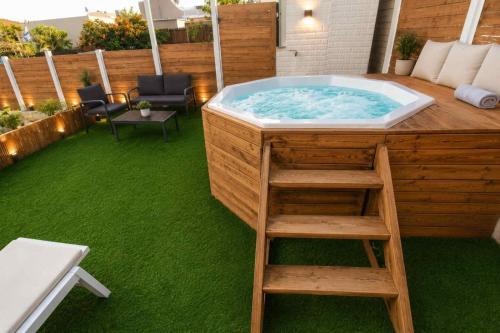 a jacuzzi tub in a deck with a ladder at Barak Royal Suites 20 sea view - ג'קוזי בחצר ומרפסות עם נוף לים in Eilat