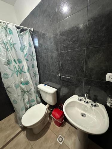 a bathroom with a toilet and a sink at Hospedaje ESMERALDA in Volcán