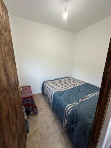 a bedroom with a bed in a white room at Hospedaje ESMERALDA in Volcán