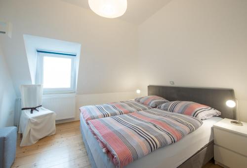 バート・ザルツフレンにあるTal-Residenzの白いベッドルーム(ストライプシーツ付きのベッド、窓付)
