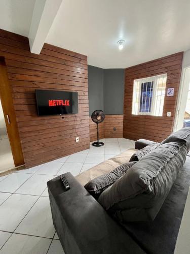 a living room with a couch and a television at 11-Casa espaçosa com garagem e Wi-Fi in São Leopoldo