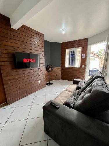 a living room with a couch and a tv at 11-Casa espaçosa com garagem e Wi-Fi in São Leopoldo