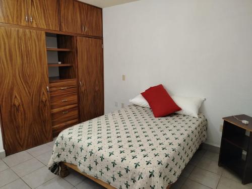 a bedroom with a bed with a red pillow on it at Casa Lago de Luz in San Juan Cosalá
