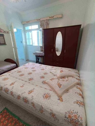 a bedroom with a bed with a dresser and a mirror at Dar arbi in Kelibia