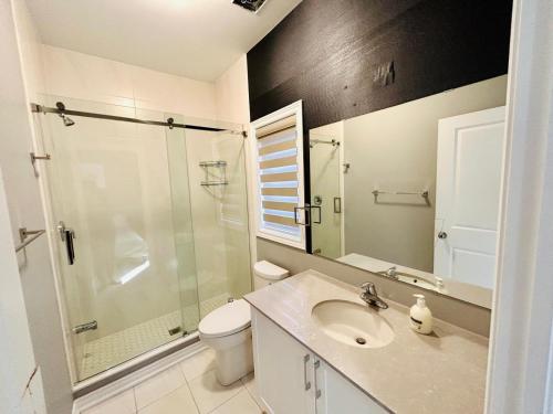 a bathroom with a sink and a shower and a toilet at The Grand Maple Residence in Brampton
