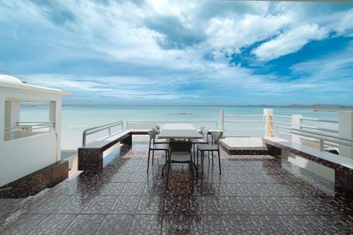 a table and chairs on a balcony overlooking the ocean at Gao Lighthouse Phala Beach in Ban Phala