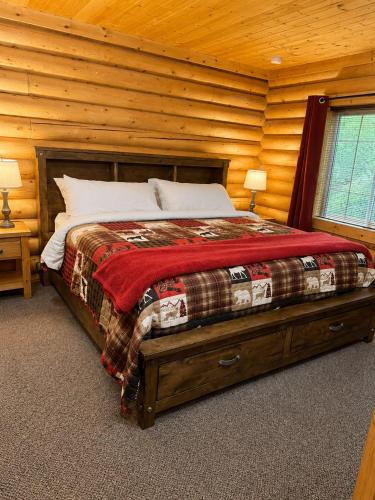 a bedroom with a bed in a log cabin at Box Canyon Cabins in Seward
