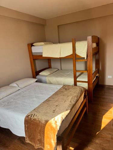 a room with three bunk beds in a room at Hotel El Galeón in Paracas