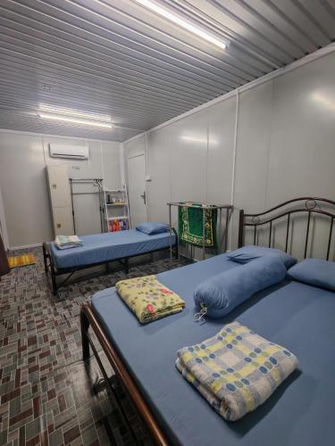 a room with two beds in a room at STUDIO HOMESTAY Arjuna in Pantai Remis