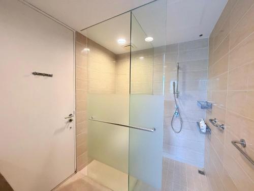 a shower with a glass door in a bathroom at By The Sea - UBTS SMART ENTERPRISE in Batu Ferringhi