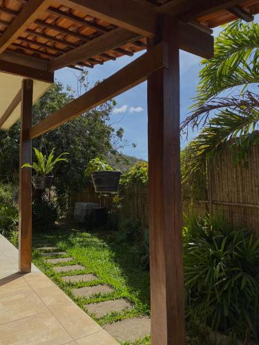 a wooden pergola in a backyard with a garden at Suites Vossoroca in Alto Paraíso de Goiás