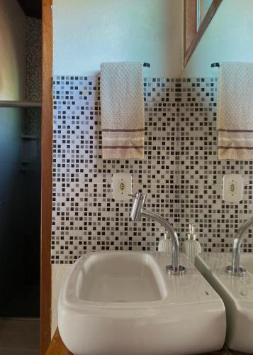 a bathroom with a white sink and two mirrors at Suites Vossoroca in Alto Paraíso de Goiás