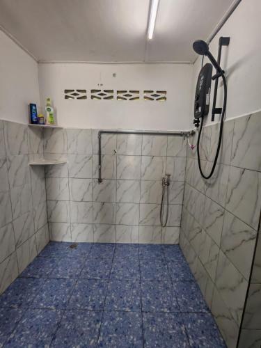 a bathroom with a shower with blue tile at STUDIO HOMESTAY Arjuna in Pantai Remis