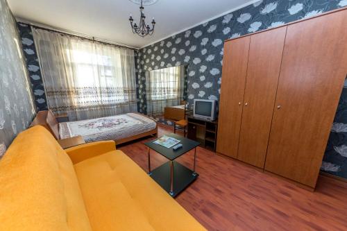 ein Wohnzimmer mit einem Sofa, einem Bett und einem TV in der Unterkunft Hotel Voikovsky in Moskau