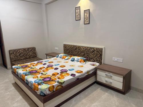 a bedroom with a bed and a table with a bedspread at Neem Tree Farm Stay in Ujjain