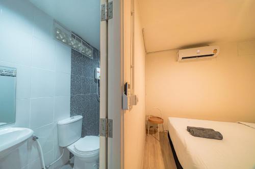 a small bathroom with a toilet and a sink at GAO Phala Beachfront Hostel in Ban Phala