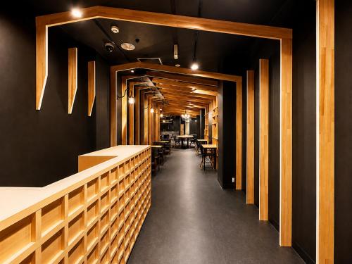 a corridor of a restaurant with tables and chairs at Namba Guesthouse HIVE in Osaka