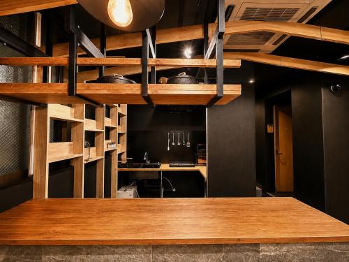 a kitchen with wooden shelves and a counter top at Namba Guesthouse HIVE in Osaka