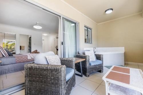 a living room with wicker chairs and a couch at Lagoons Resort Studio 64 in Agnes Water