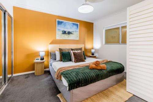 a bedroom with a large bed and orange walls at Lagoons Resort Apartment 63 in Agnes Water