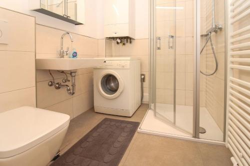 a bathroom with a washing machine and a sink at Deichbrise in Greetsiel
